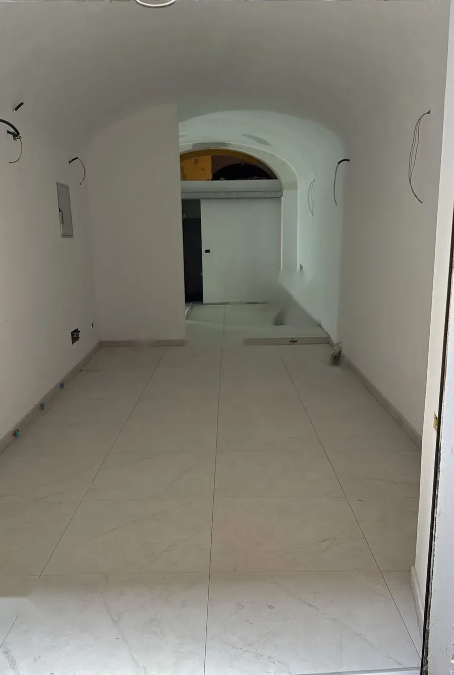 Ambiente con soffitto a volta ristrutturato e nuovo pavimento in gres effetto marmo